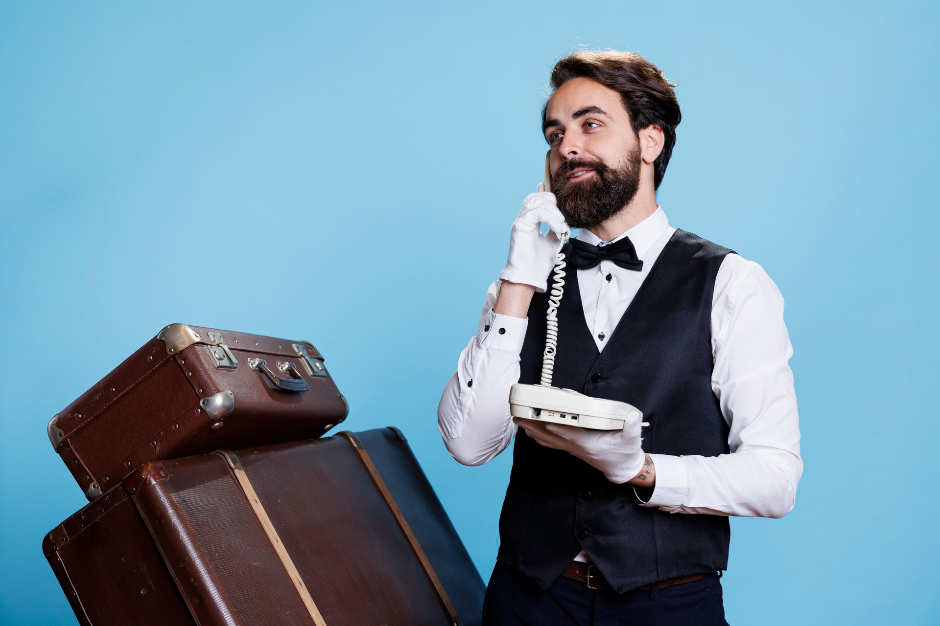 Stylish bellboy answers landline phone